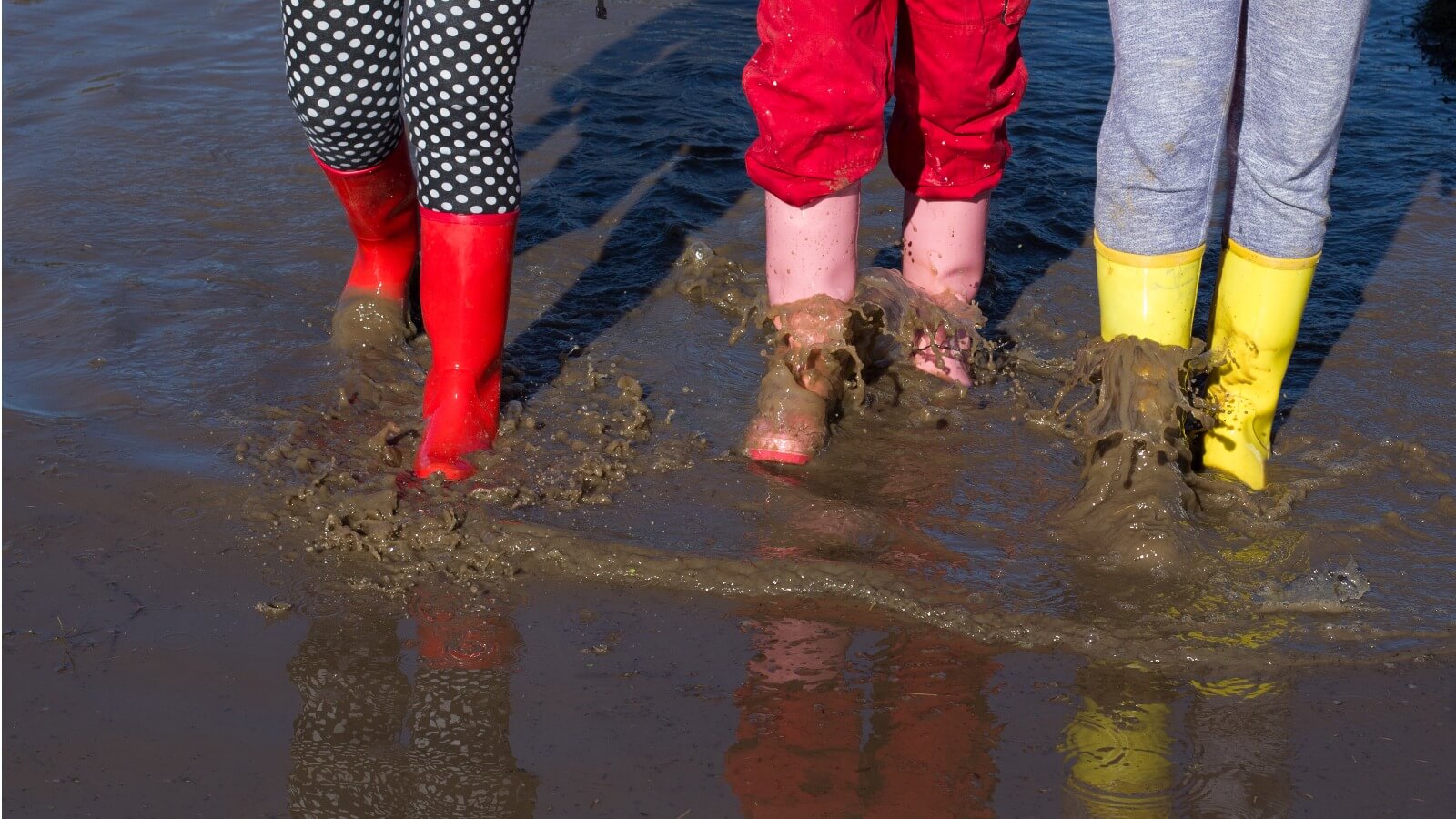girls-in-gumboots-walking-in-puddle-picture-slider